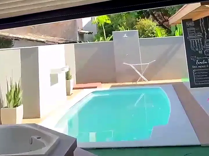 Pergolado retrátil com lona sobre área de piscina